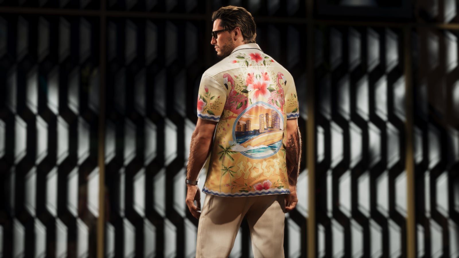A muscular man is seen from behind wearing a floral Hawaiian shirt and cream trousers, standing in front of a metal grate.